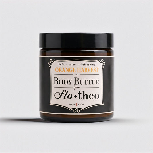 Jar of body butter labeled 'Orange Harvest' by 'Flo & Theo' on a light gray background