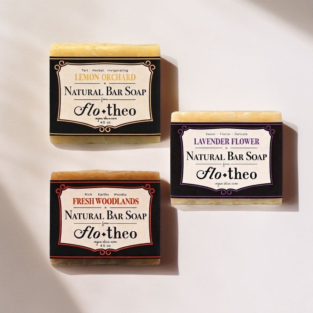 Three bars of flo+theo natural bar soap with different scents on a light background